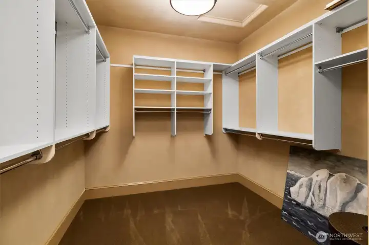 An oversized walk-in closet with custom built-in organization offers generous storage and an effortless way to keep everything in its place.