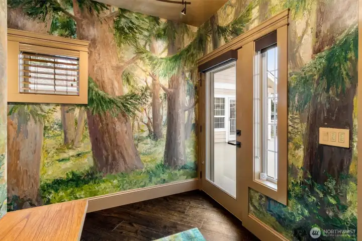 The entry marks the beginning of an 80-foot custom mural by local artist Jennifer Bowman, with direct access to the front deck extending the experience outdoors.
