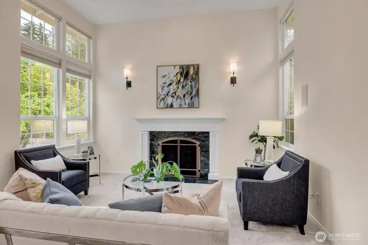 This living room is a great place to unwind with amazing natural light from the oversized windows, soaring ceilings and gas fireplace with natural stone surround.