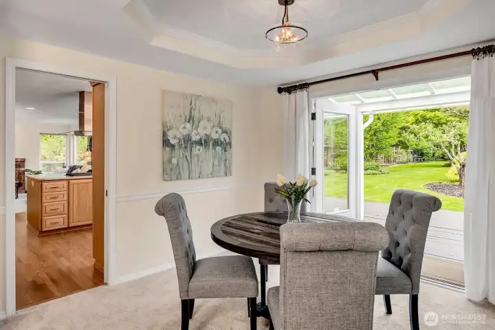 Dining room boasts tray ceiling, chair rail and French doors opening to a covered deck.