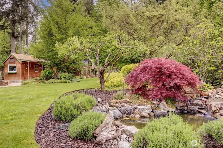 Soothing water feature pond can be enjoyed from the decks.  Across the yard is an adorable chicken coop with shed and the fenced raspberry garden just beyond.