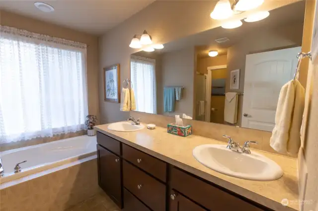Five-piece primary bath with dual sinks, soaking tub, water closet, and separate shower.