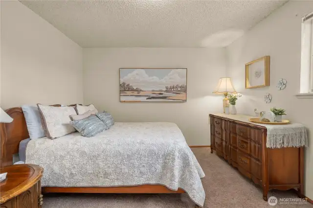 First bedroom at the top of the stairs, complete with large closet, small built in desk, and large window overlooking the front yard.