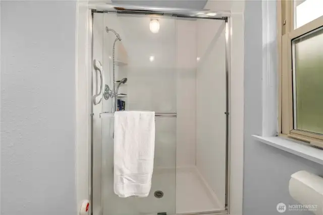 Large walk in shower with built in storage in the primary suite