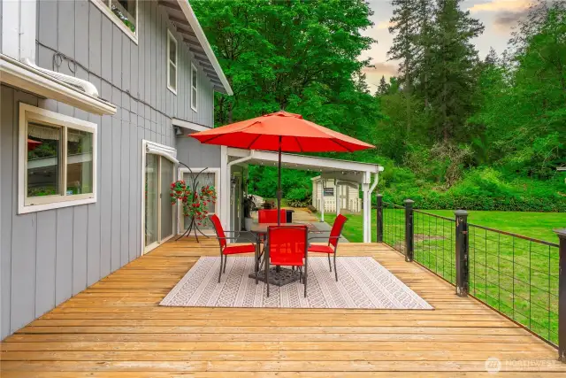 Large deck with view of kitchen access and covered patio just a few steps down