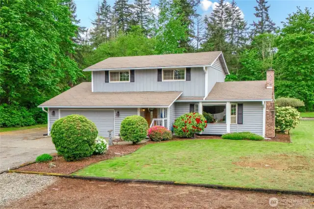 Front of home with large grassy area and ample parking