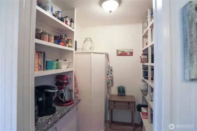 This walk-in pantry has built-in shelves that provide great storage space for both dry goods and canned food, as well as a place to park your smaller appliances.