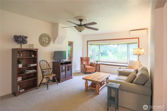 Cozy living room with sweet window seat.  Mini splits in the living room and dining room provide warmth on cold winter days and air conditioning on those hot summer nights.