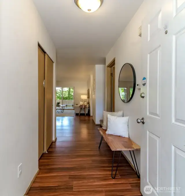 Entry shot from the front door shows the hardwood laminate floors throughout the main level. Coat closet to the left, door on the right leads to the utility room and the garage.