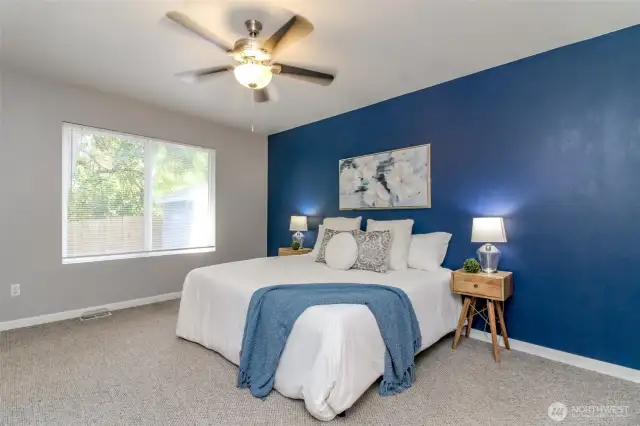 This view of the primary bedroom faces the backyard and storage shed. The walk in closet is to the left of the window.