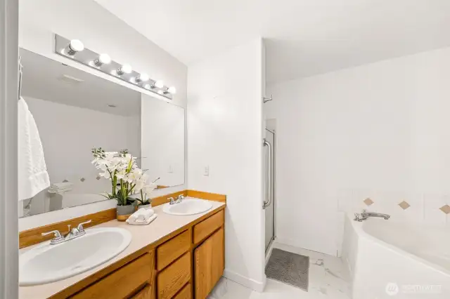 The Primary Bath with large corner soaking tub, is a wonderful oasis for relaxing, and features brand new sinks, new flooring, and a new toilet.