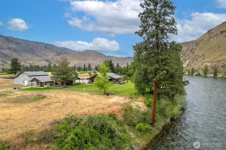 This riverside property offers unmatched scenery with sweeping mountain views and direct access to the water. Expansive lawns and mature trees create a private retreat just steps from the river’s edge.
