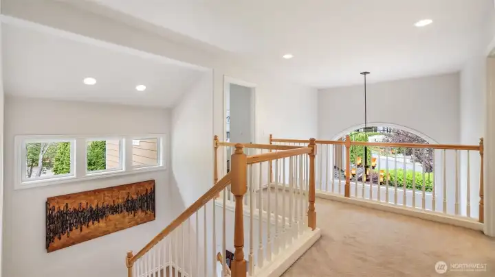 Enjoy this light-filled upper landing overlooking the grand entry, accented by elegant railings and architectural charm.