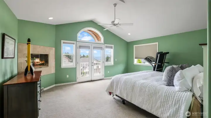 Relax in this serene and sophisticated primary suite featuring vaulted ceilings, a charming fireplace, and French doors to your own private balcony.