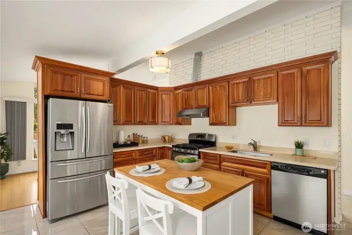 The kitchen has been updated with newer stainless-steel appliances, cabinets, and countertops.