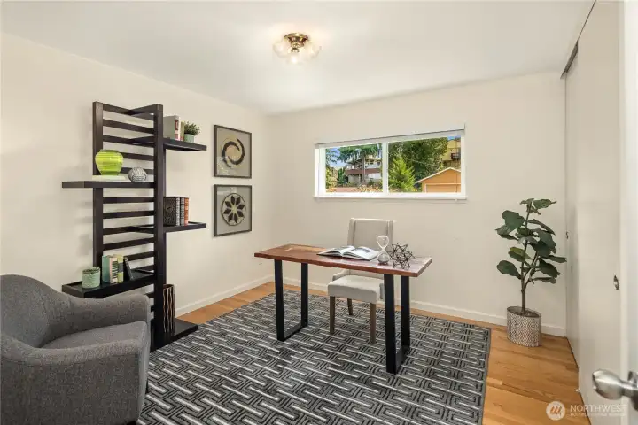 Currently staged as an office, the first bedroom offers oak hardwoods.