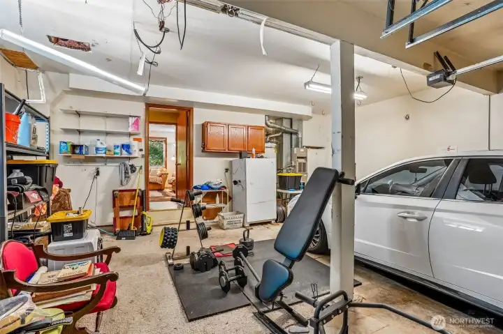 Spacious attached garage with room for parking, storage, workshop, or home gym setup