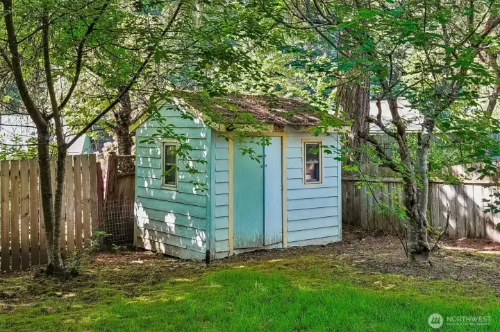 A detached shed surrounded by greenery feels very “secret garden meets PNW” and honestly we are here for it.