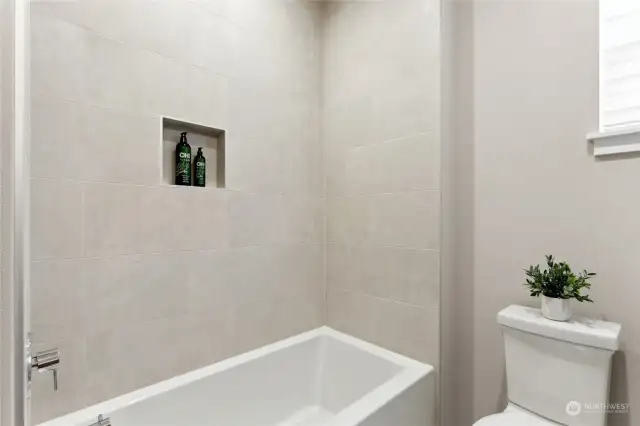 Upstairs hall bathroom with the tub and full height tile surround.