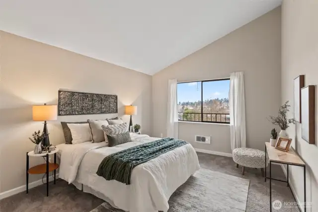 Inside the large bedroom, find lovely vaulted ceilings.