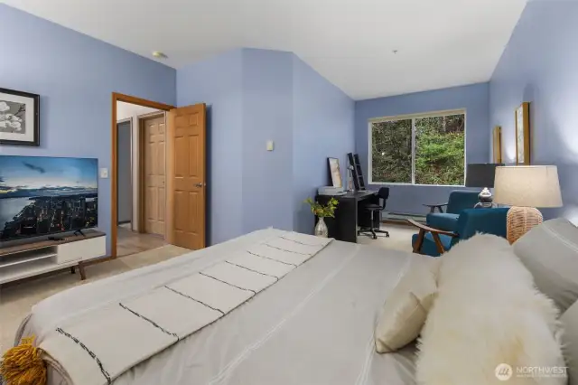 Spacious primary bedroom featuring ample room for a home office and cozy lounge seating. Enjoy the comfort of a generous walk-in closet and an en-suite full bathroom—your perfect retreat for rest, work, and relaxation.