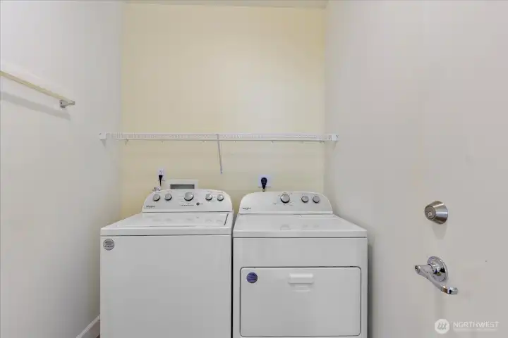 Full size wash/dryer near the garage entrance.