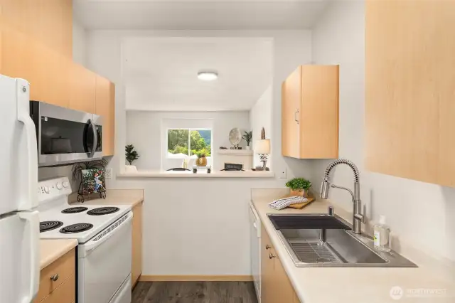 Sparkling kitchen with new sink, fridge and microwave, opening to dining and living room