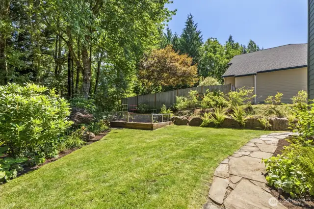 The fully landscaped back yard provides a spot to garden, plus open grass to spread out or enjoy lawn games.