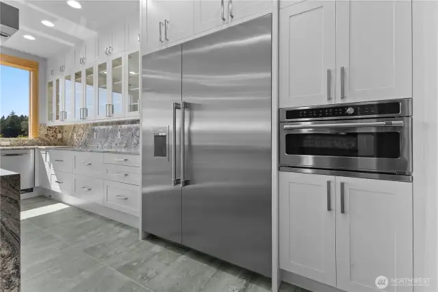Over-sized Thermador side-by-side refrigerator/freezer makes diamond shaped ice cubes. Built in microwave. Toe kick sweeper vacuum.