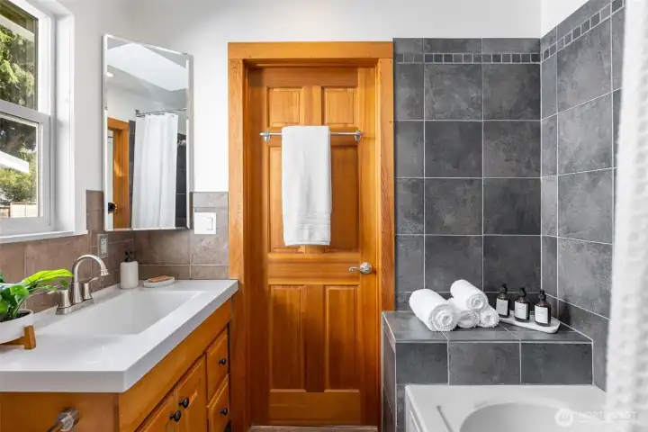 The main floor jack-and-jill bathroom features heated tile floors. Soaking tub with shower and a skylight.