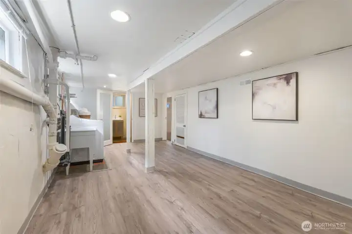 The finished basement features new LVP floors, a laundry area,  a half bathroom, and a fourth bedroom.