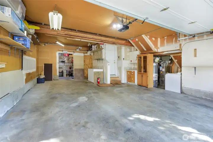 Large garage area can hold 2 cars deep on left side or shop/storage area. Rear shop room w/ skylight & backyard entry fits your hobby needs.