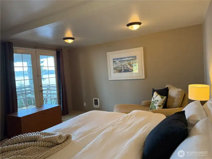 Primary bedroom french doors leading out to the waterfront deck.