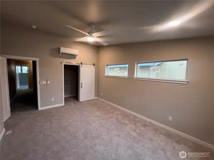 Spacious primary with barn door to walk-in closet