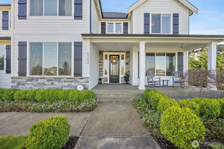 Beautiful covered front porch and gorgeous landscaping will welcome all of your friends and family.