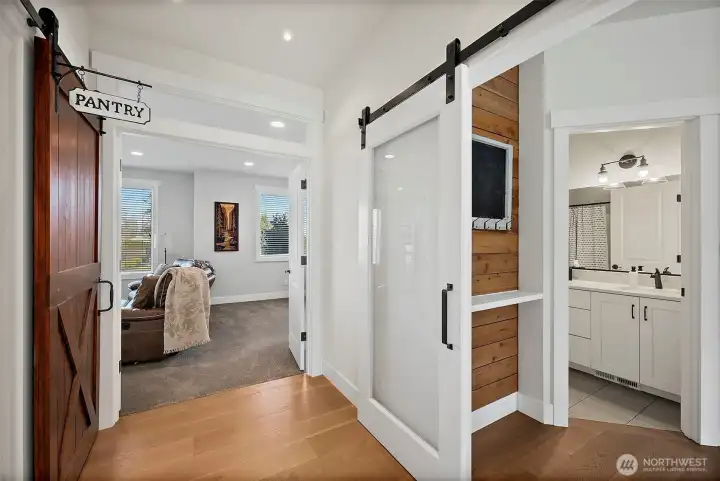Just around the kitchen corner is more storage under the stairs, this large walk in pantry on the left and then go either ahead to this bonus den space or right into a 3/4 bath and mudroom. Easy to turn this whole space into a primary master bed and bath if those are your needs in the future.