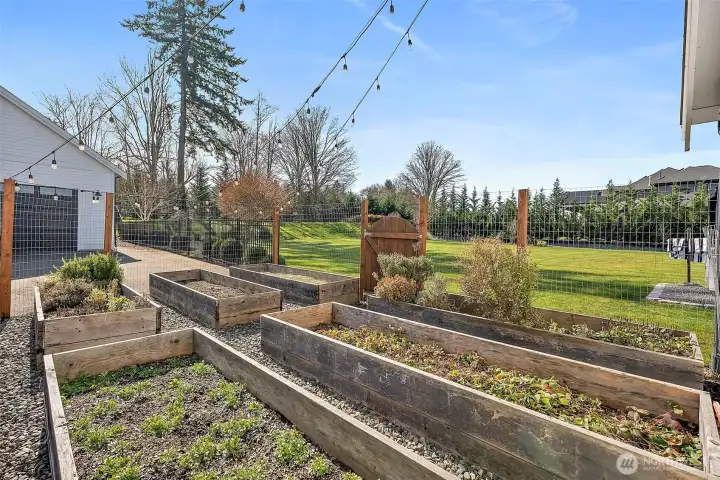 This garden is ready for you. Raised beds, private space and produces so many goodies year after year. Tucked right behind one of the detached garage spaces which houses all your mowers and tools.
