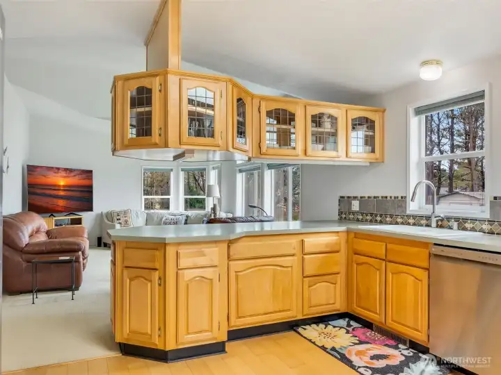 oak cabinetry and large windows overlooking the backyard.