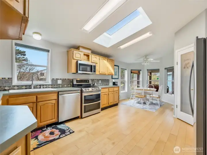 oak cabinetry and large windows overlooking the backyard. Well taken care of appliances and skylights bring ample light.