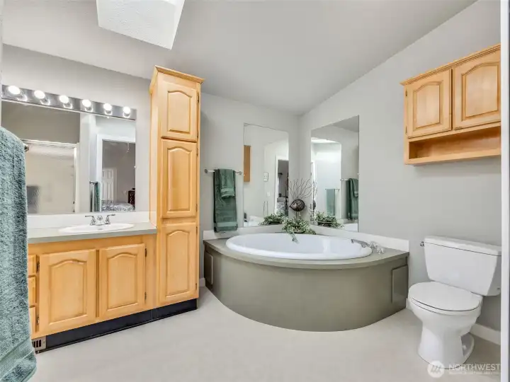 Primary bedroom with closet and attached full bathroom. Soaking dub, skylights, vaulted ceilings, and shower make a large primary suite.