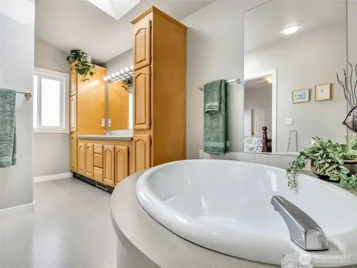 Primary bedroom with closet and attached full bathroom. Soaking dub, skylights, vaulted ceilings, and shower make a large primary suite.
