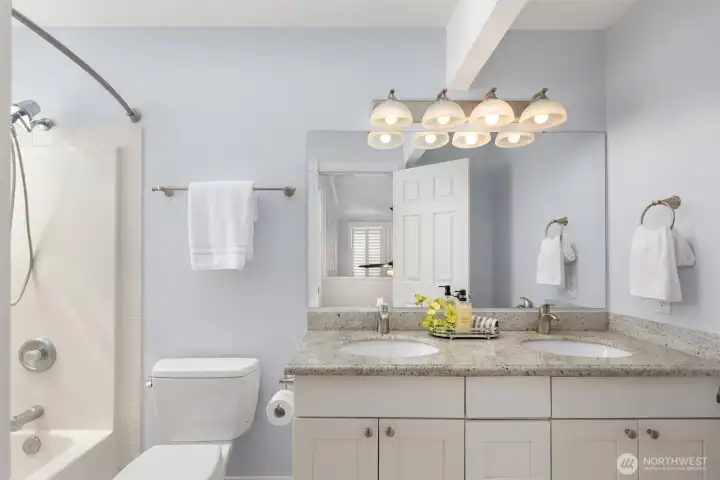 The main hallway bathroom upstairs with dual sinks, solid surface countertops, tiled flooring and a tub/shower combo. The main hallway bathroom upstairs with dual sinks, solid surface countertops, tiled flooring and a tub/shower combo.