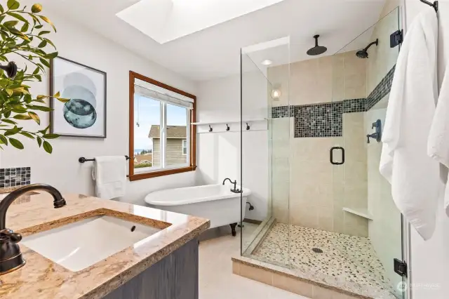 Updated ensuite bath features glass enclosed tile shower, clawfoot tub and dual sink vanity & rain showerhead in shower