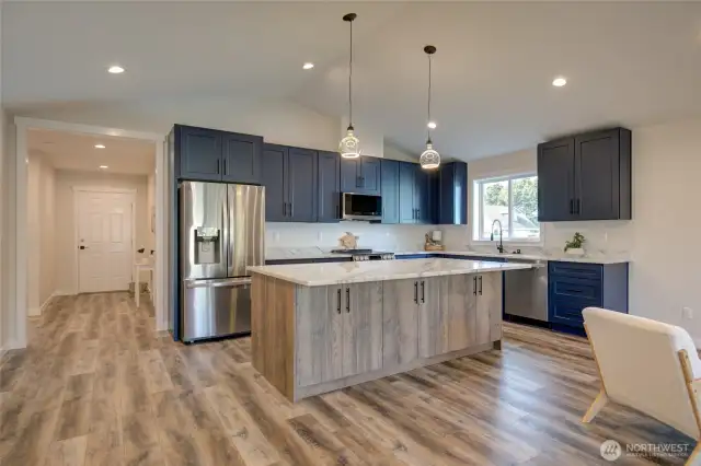 Large kitchen with two tone cabinets, spacious island and quartz countertops. Plenty of counterspace and cabinets. All appliances included!