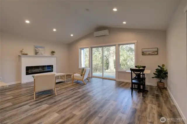 Open floor plan with vaulted ceiling, electric fireplace with custom mantle. Minisplit offers efficiency and year round comfort. Plenty of space for a large dining room set or office area.