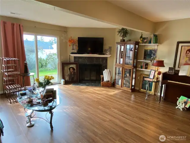 The main living area has laminate wood flooring and a wood burning fireplace, perfect for enjoying a cool evening.
