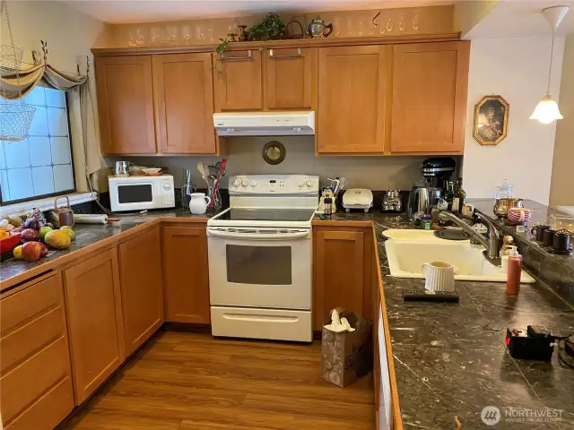 The kitchen boasts tile, marble counters and laminate wood flooring.