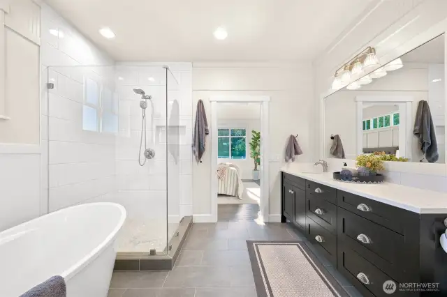 Primary bath with soaking tub and large walk in tiled shower.