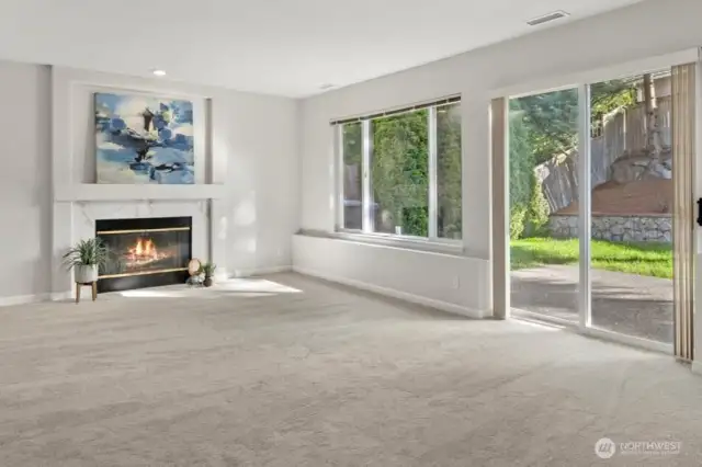 Downstairs family room w/wood fireplace opens to the back patio.