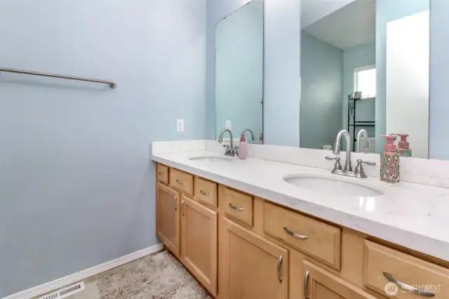 Double vanity with quartz counters in hall bath.